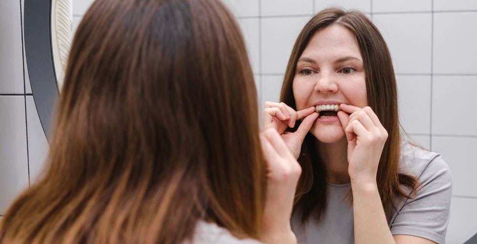 Woman looking at smile in mirror